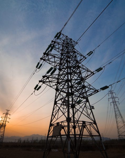 High voltage electricity pylon over sunset.